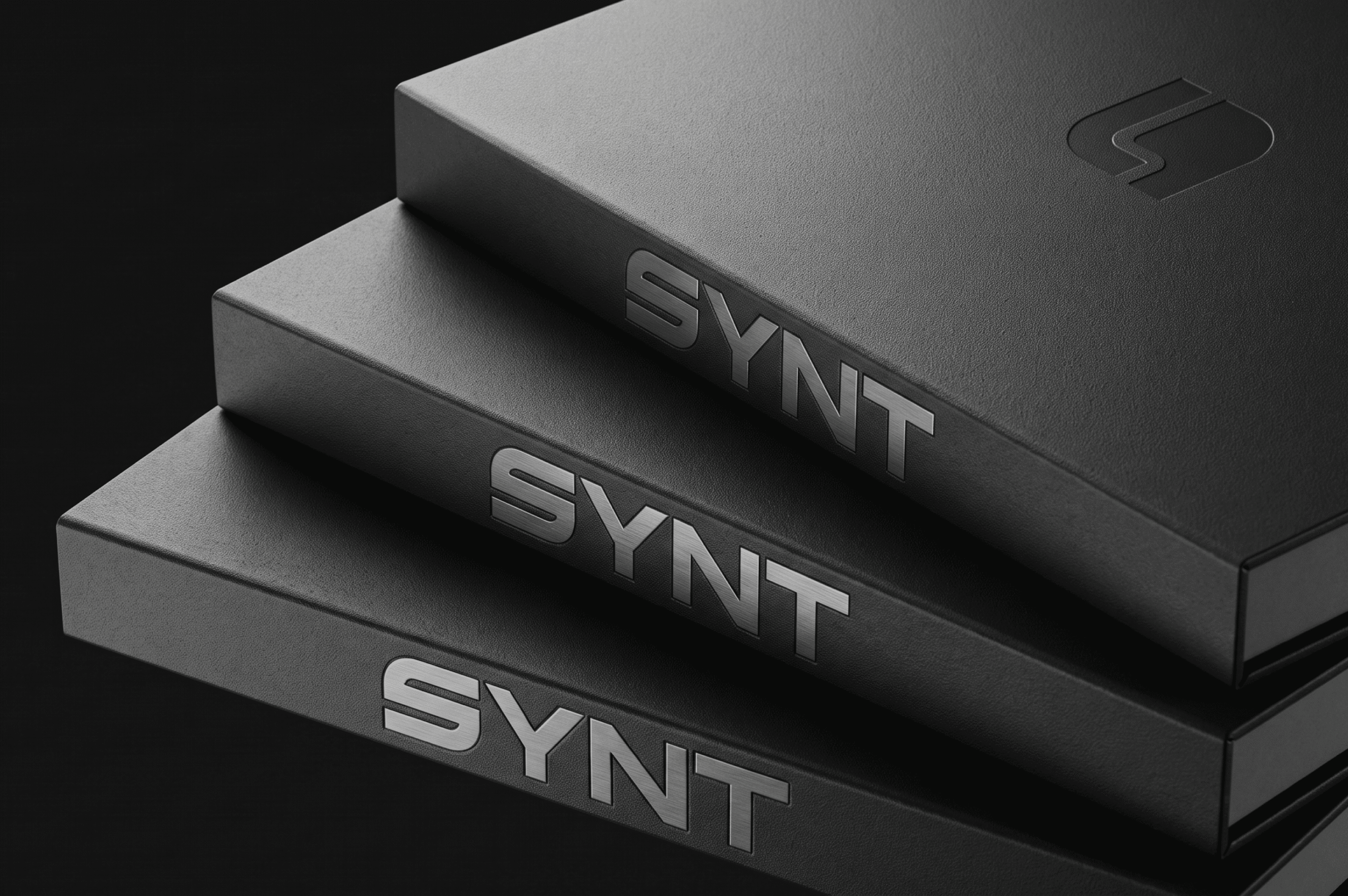 Stacked black SYNT branded packaging boxes with logo