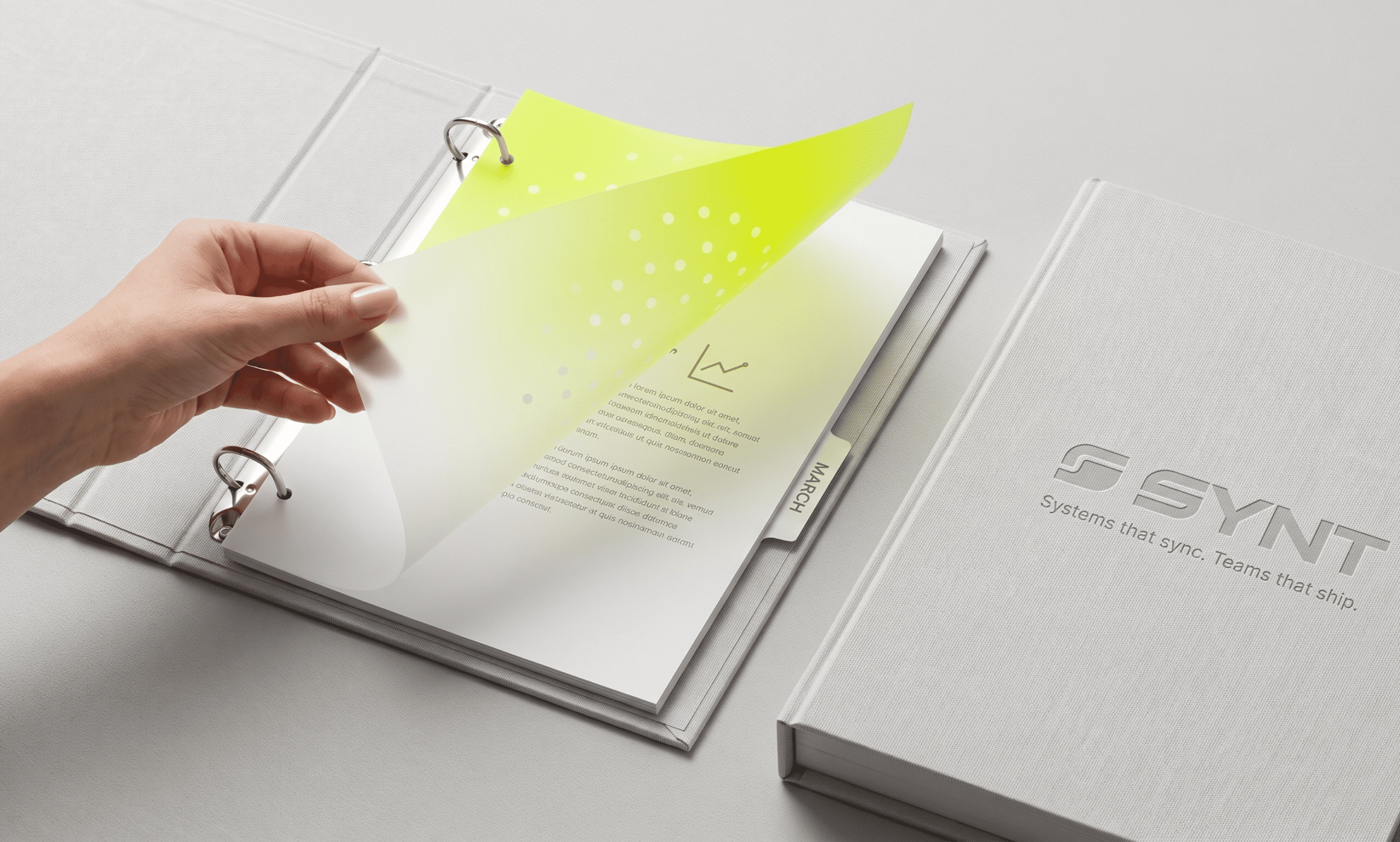 Hand flipping through SYNT branded brochure catalog pages