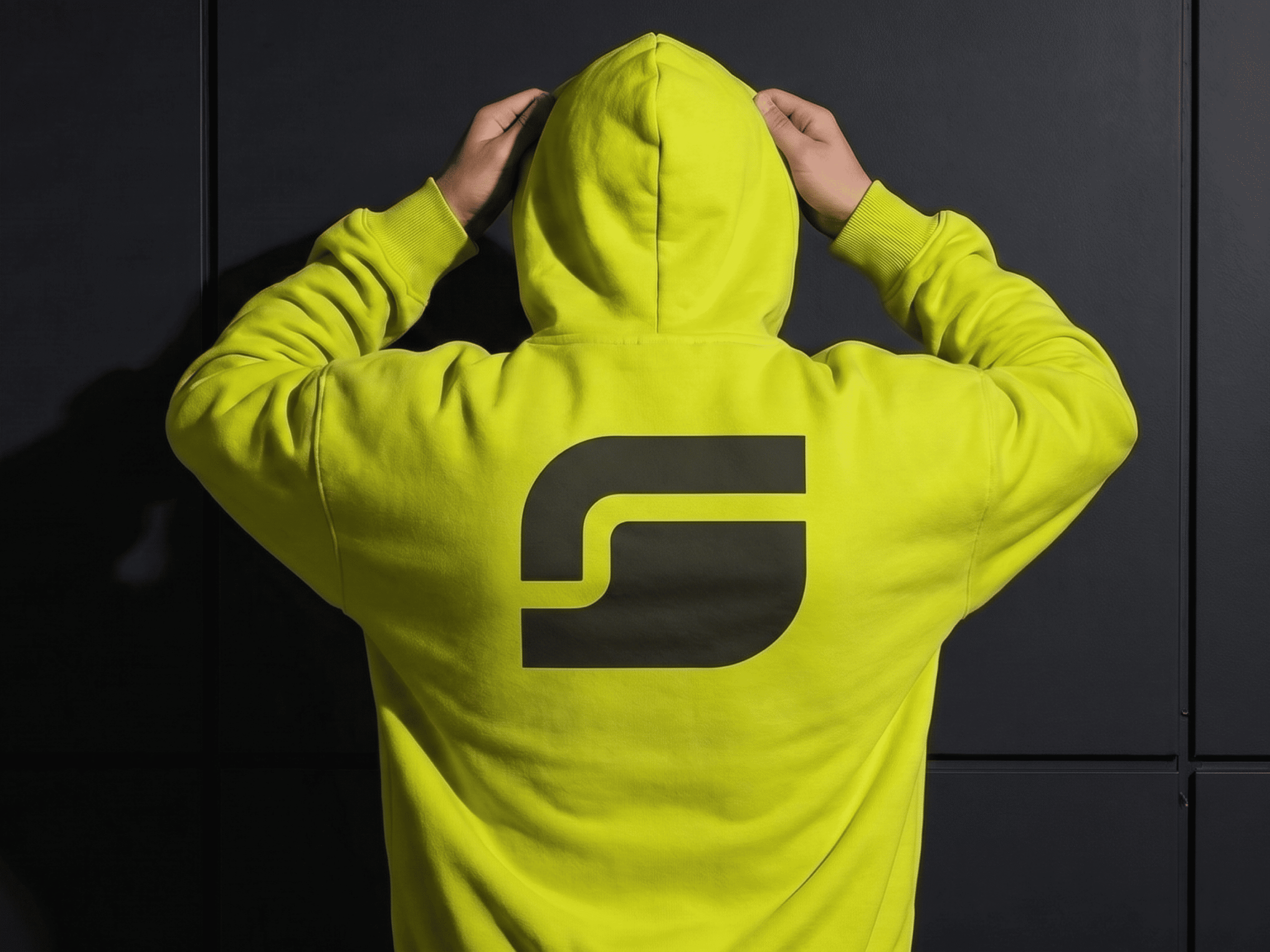 Person wearing yellow SYNT hoodie with logo on back